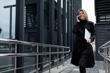 woman investor talking on the phone about a deal in the business district of the city