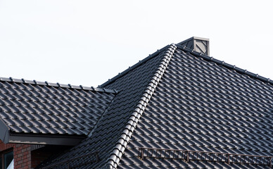 Fototapeta na wymiar Dark brown metal roof tiles. The roof of corrugated sheet