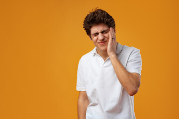 Young handsome man over yellow background touching mouth with hand