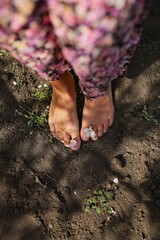 a girl with bare feet walks on fresh black earth in an apple orchard, focus on female feet, spring mood