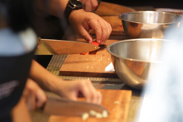 Adult students learning recipe and preparing meal in cooking class