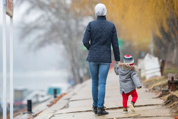 A mother with a child walking on a cold autumn day © Vesna