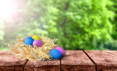 Easter eggs on a wooden table with a green nature background