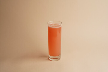 Glass of 100% grapefruit juice with sliced fruits