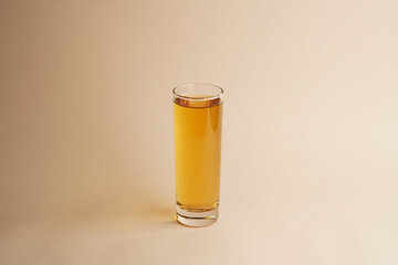 Glass of apple juice on pastel color background
