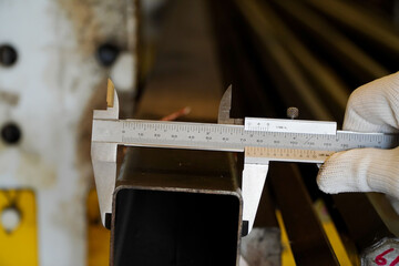mechanic uses vernier to measure the size of the mild steel box section,Galvanize box steel