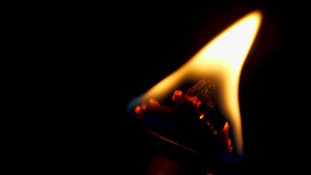 Flame on a candle with wood wick macro slow motion