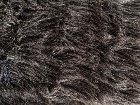 Long gray fake fur texture cover. Synthetic fiber soft faux fur macro fabric photo. Monochrome fluffy furry surface for digital paper design Winter clothes coat backdrop Textile mat close-up wallpaper