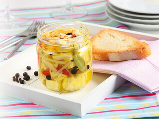 cheese marinated in olive oil with fresh herbs in glass jar