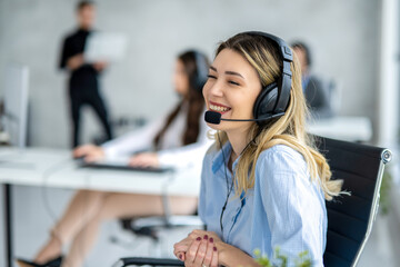 Adorable blond haired woman with headset chatting with customer at call center. - obrazy, fototapety, plakaty