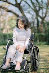 Fototapeta na wymiar Elderly patient sitting in a wheelchair outdoor, knee pain.