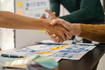 designer team shake hands confidently professional investor working with new startup project at an office meeting.