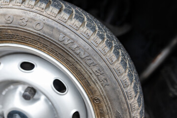 Side view of a winter tire on the rim on an old french car