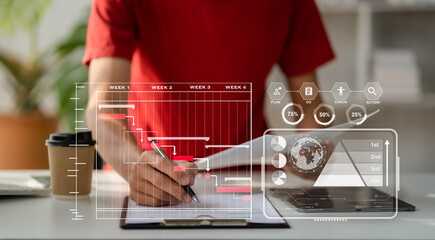 Businessman hand Project manager working and update tasks and Gantt chart scheduling virtual diagram.with smart phone, tablet and laptop in office.