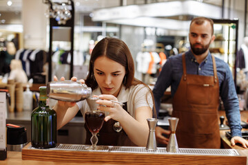 A man and a girl make coffee at a coffee machine in a coffee shop