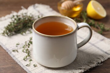 Obraz na płótnie Canvas Aromatic herbal tea with thyme on wooden table