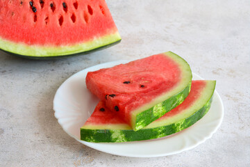 two slices of watermelon on a plate isolated on marble background