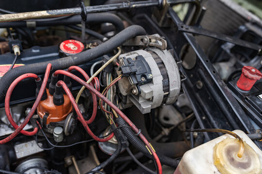 Shot of the engine compartment of a classic car with the engine, cables and alternator