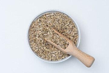 Pestki słonecznika łuskanego w okrągłej misce z drewnianym nabierakiem 