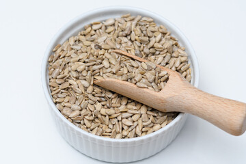 Ziarenka łuskanego słonecznika w białej misce z czerpakiem