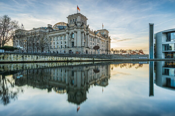 Government district in Berlin. Parliament and government buildings in the capital of Germany. Reflection on the water surface of the river Spree. Cloudy sky at sunset