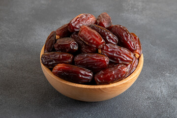 Date fruits in wooden bowl,on black background
