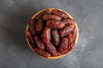 Date fruits in wooden bowl,on black background