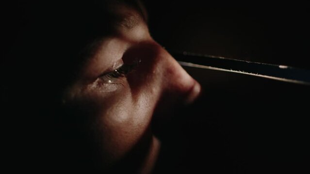 Close-up of a woman watching through a crack