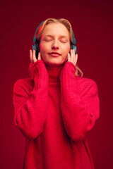 Portrait of a calm woman listening to relaxing music isolated on magenta background. Viva magenta, color of the year.