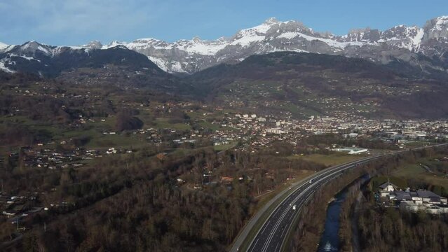 Aerial panning left over a green valley and mountains range. Arve valley and the town of Sallanches in Haute Savoie, France.