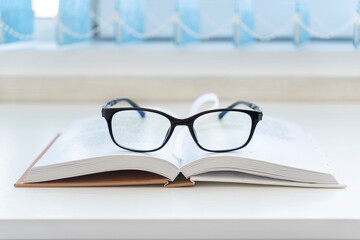 pair of designer glasses on an opened book.