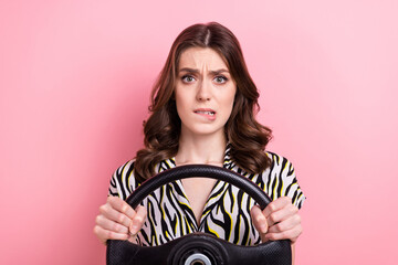 Photo of worried anxious lady biting lips hands hold wheel steering isolated on pink color background - obrazy, fototapety, plakaty
