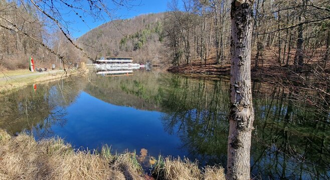 Thal, Graz, Austria-03.04.2023:Natural lake with new, modern building on the shore of Thalersee. Thal is a favorite tourist destination and the village where was born and lived Arnold Schwarzenegger.