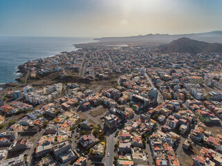 Obraz premium Aerial photos of Praia, the capital city of Santiago Island, Cabo Verde, reveal a bustling metropolis with a vibrant culture, stunning architecture, and breathtaking views of the Atlantic Ocean.