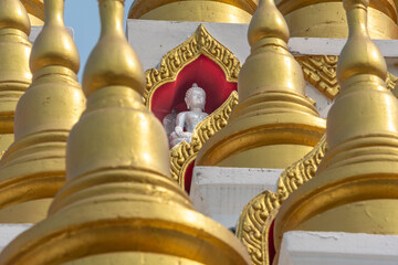 Fototapeta na wymiar Buddha statue and golden stupas at the Wat Manee Praison temple in Mae Sot Thailand