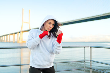 Woman boxing outdoors blue sky background.