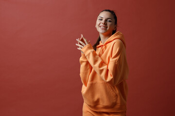 Young positive smiling woman in orange fitness sport outfit cloth dancing.