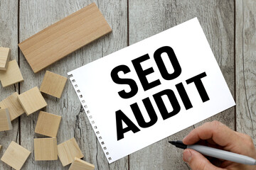 SEO AUDIT. Business concept.man woman hand writes tex. text on notepad