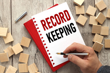 record keeping man's hand writes tex. notepad next to the cubes. business concept. education...
