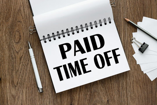 Paid time off symbol. open notepad with text. wooden background. Business, paid time off concept, copy space.