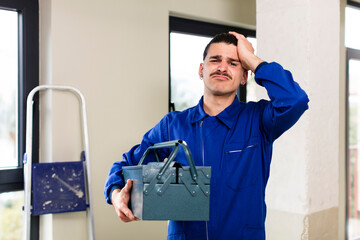 young handsome man handyman or housekeeper concept at home interior