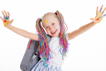 Modern small school girl stands on white background isolated holding backpack looking at camera posing in stylisg clothes laughing back to school concept.