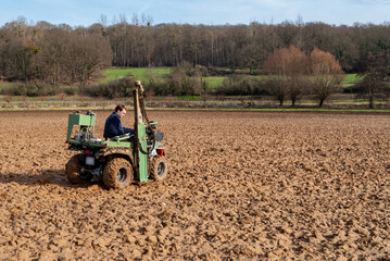 Obraz premium Mesure annuelle de reliquats azote dans une parcelle. Prélèvement effectué à l'aide d'un Quad équipé d'une tarrière hydraulique. Préleveur effectuant un prélévement