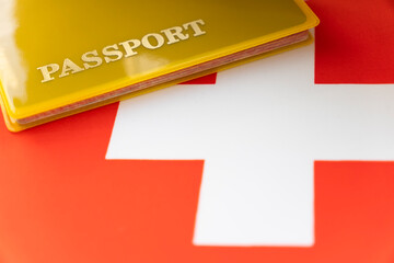 Flag of Switzerland with passport. Travel visa and citizenship concept. residence permit in the country. a yellow document with the inscription passport is on flag. Close up, top view