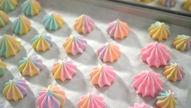 Step by step. Piping unicorn meringue cookies to the baking sheet lined with a parchment paper.