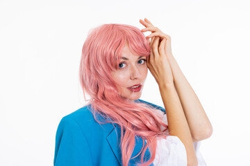 Delightfuly young woman in pink wig posing for camera touching her face with handslooking at camera...