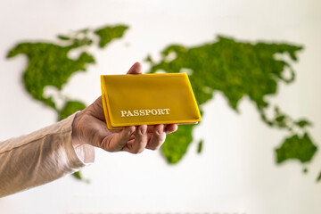 Hand holding the passport against world map. tourists travel concept.
