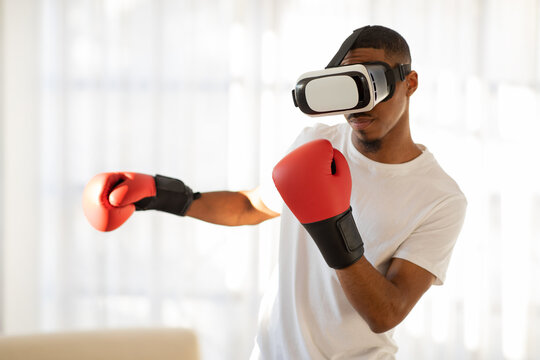 Sportsman in VR headset and boxing gloves punching someone