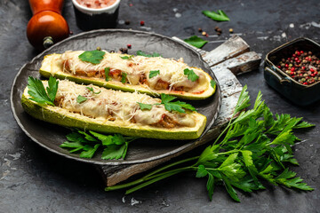 Zucchini stuffed with meat on a dark background. Ketogenic diet meal. place for text, top view