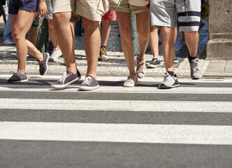 Many people walking in the city center of Porto. Pedestrians crossing the busy street on the...